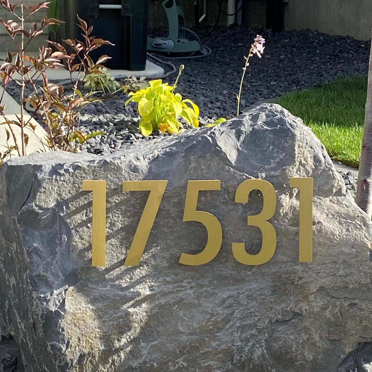 Custom Gold Anodized Aluminum House Numbers installed on a landscape Boulder
