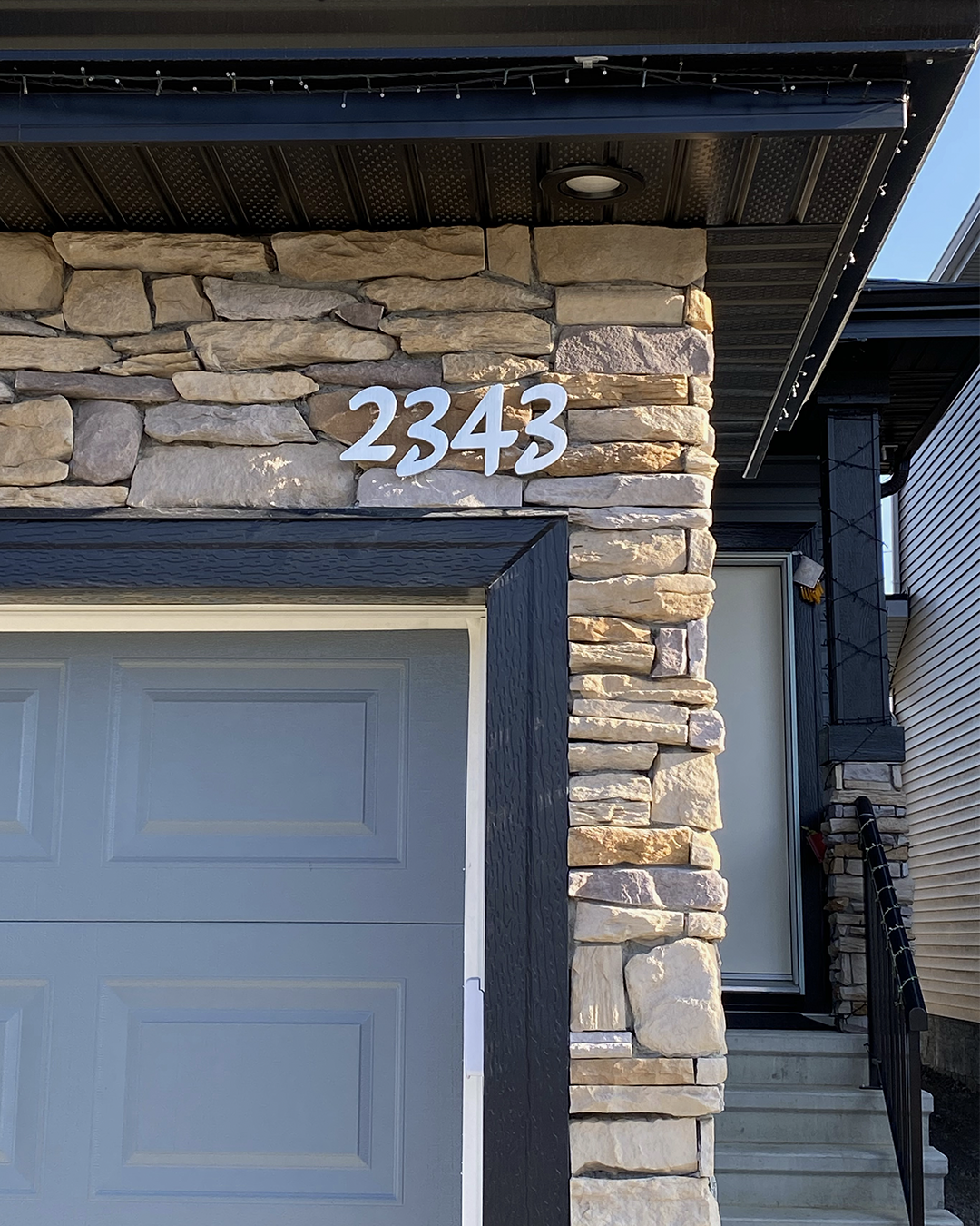 Aluminum Floating House Numbers in a custom font installed above a garage door