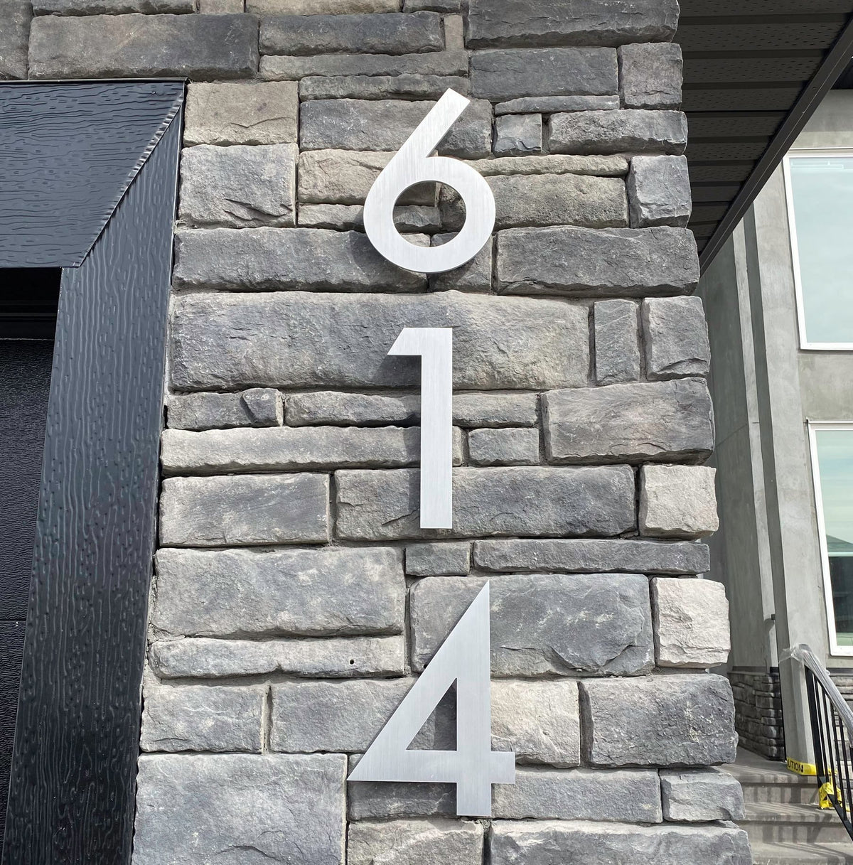 Vertical Aluminum House Numbers installed on stone 